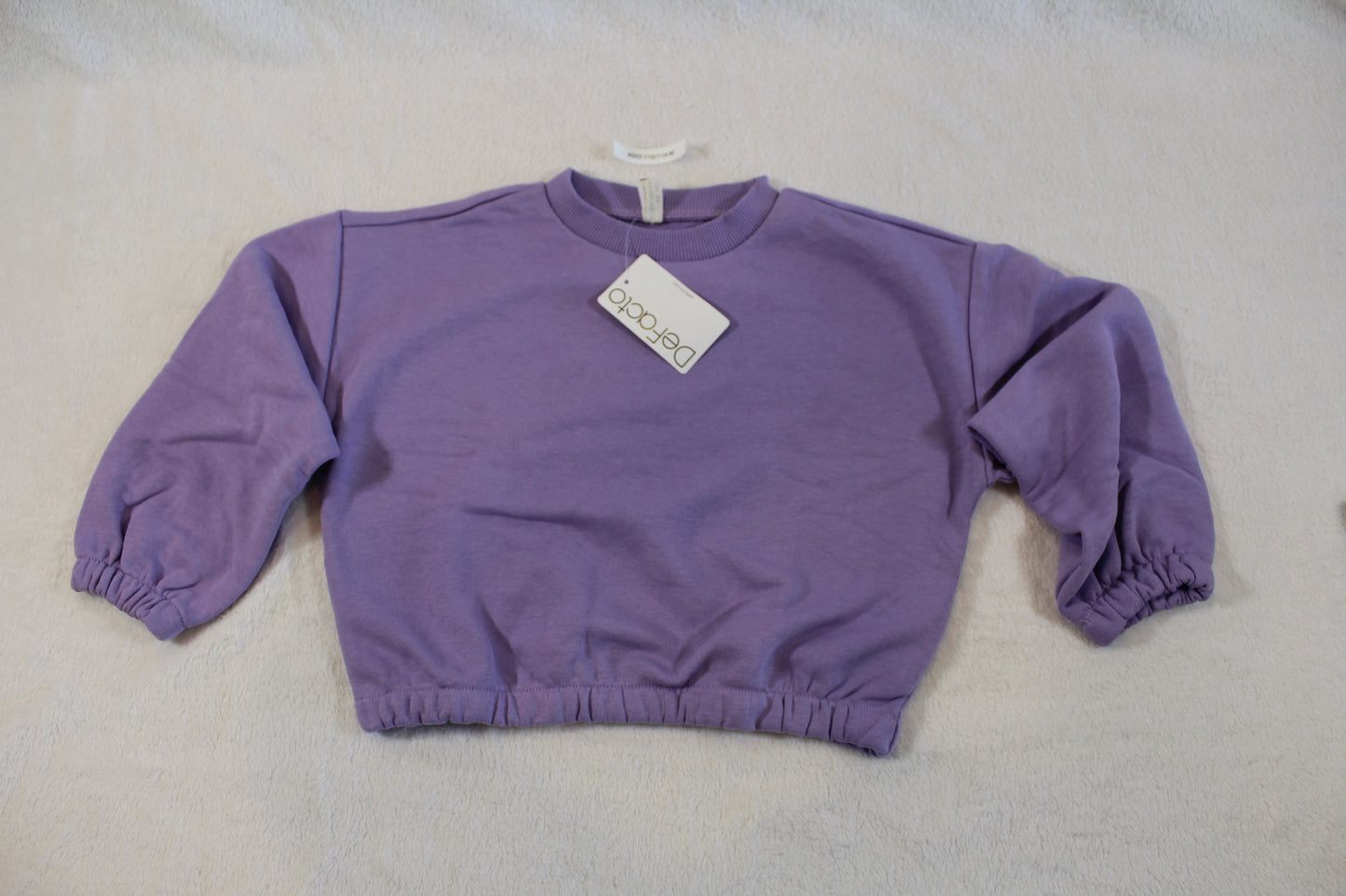 110/116 schöner Uni Pullover in soft purple with elastic cuffs and hem, laid flat on a light background, showcasing a casual and comfortable design.