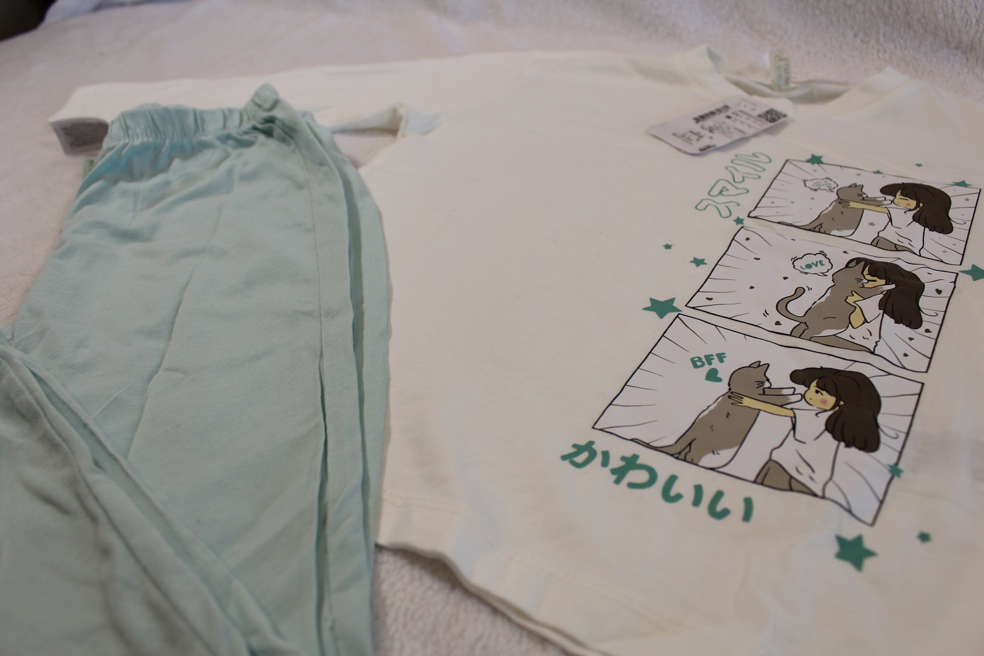 Schlafanzug 110/116 featuring a long-sleeve white top with a cute illustrated comic of a girl and dog, paired with soft light blue pants, comfortable for children.