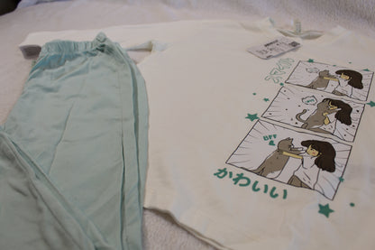 Schlafanzug 110/116 featuring a long-sleeve white top with a cute illustrated comic of a girl and dog, paired with soft light blue pants, comfortable for children.