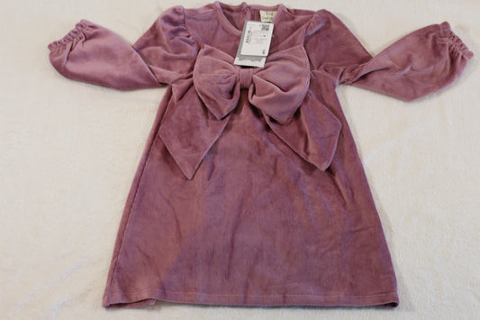 Pink velvet long-sleeve dress with a large front bow, designed for toddlers, labeled 92/98 süßes Kleid, presented flat on a light surface.
