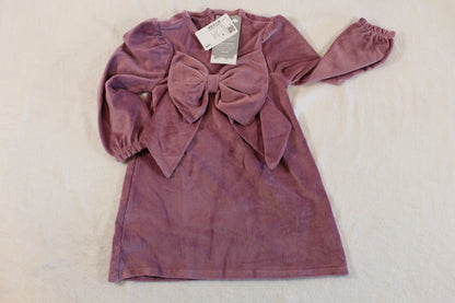 A soft velvet purple long-sleeve dress with a large front bow detail, labeled 92/98 süßes Kleid, suitable for children, combining charming style and cozy fabric.