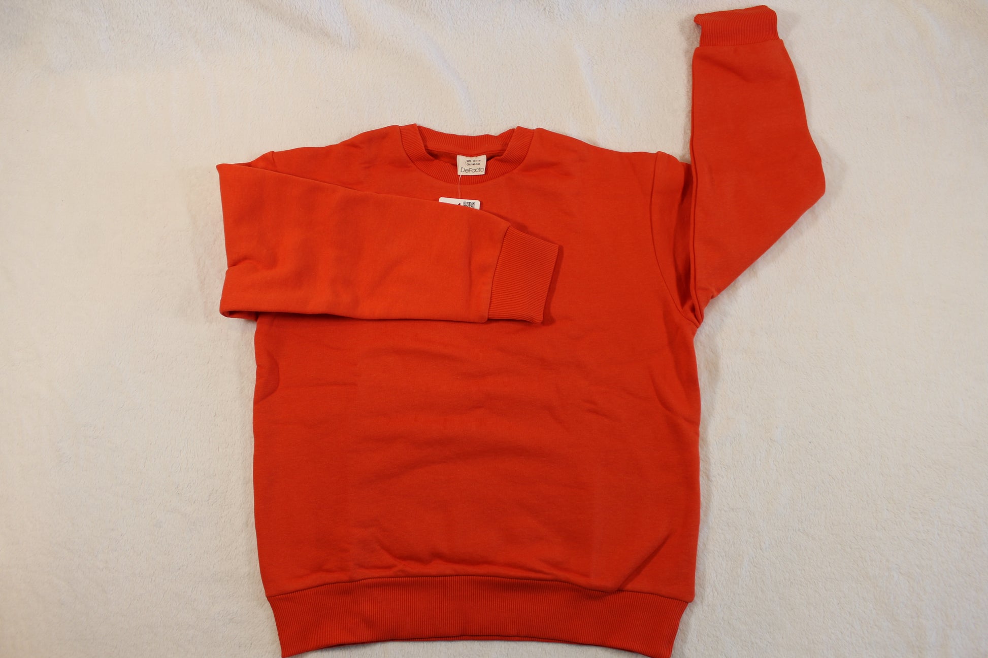 140/146 Uni Pullover Jungs in bright orange laid flat, showing long sleeves and ribbed cuffs on a light background, suitable as an affordable secondhand top.
