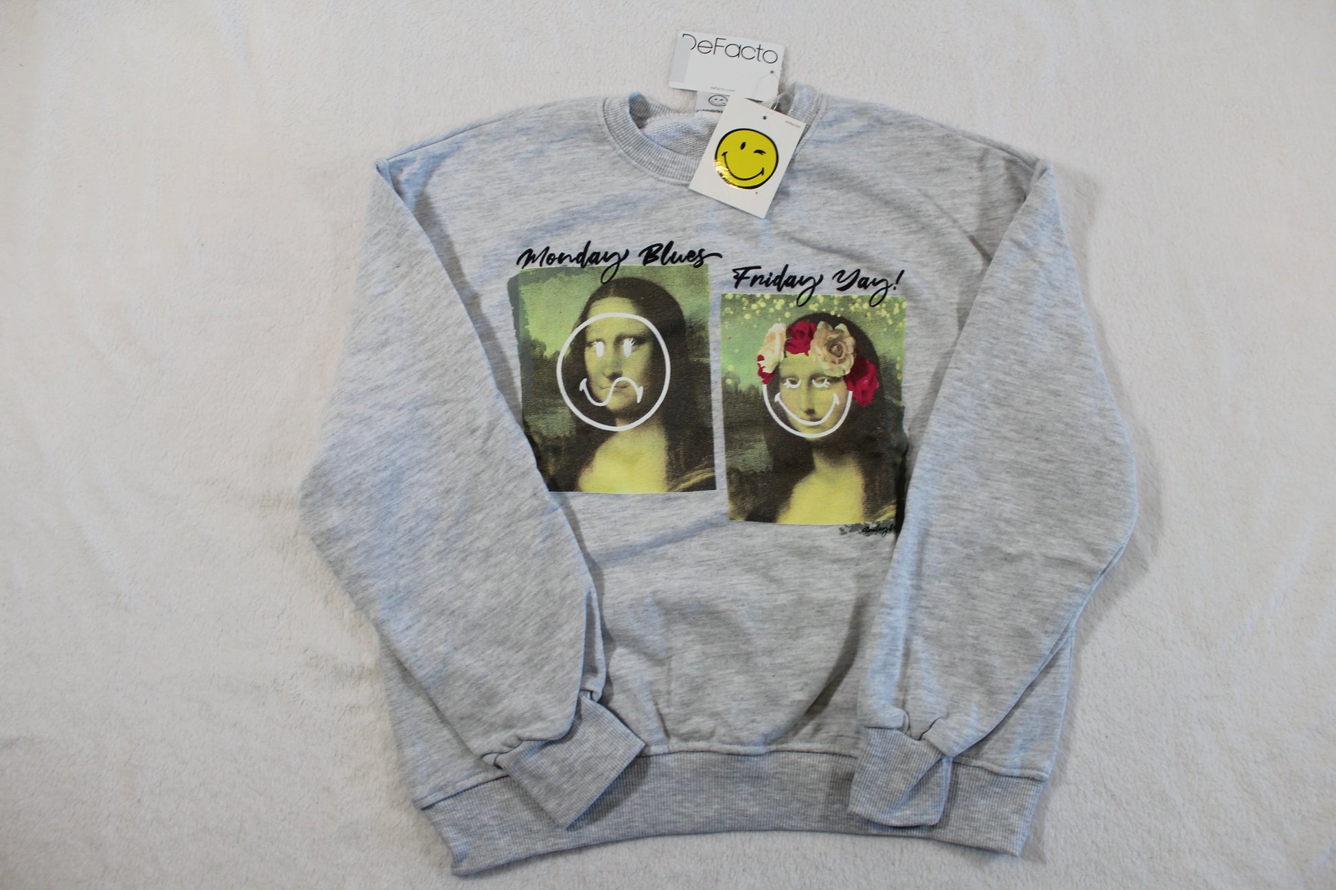 134/140 Monalisa Style Pullover in light gray featuring two modified Mona Lisa prints with playful smiley face graphics and text on the front.