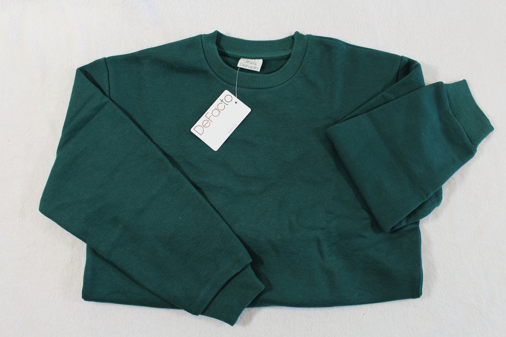 134/140 Uni Jungs Pullover in dark green, long-sleeved with ribbed cuffs and collar, laid flat on a white surface, showcasing a classic casual design.