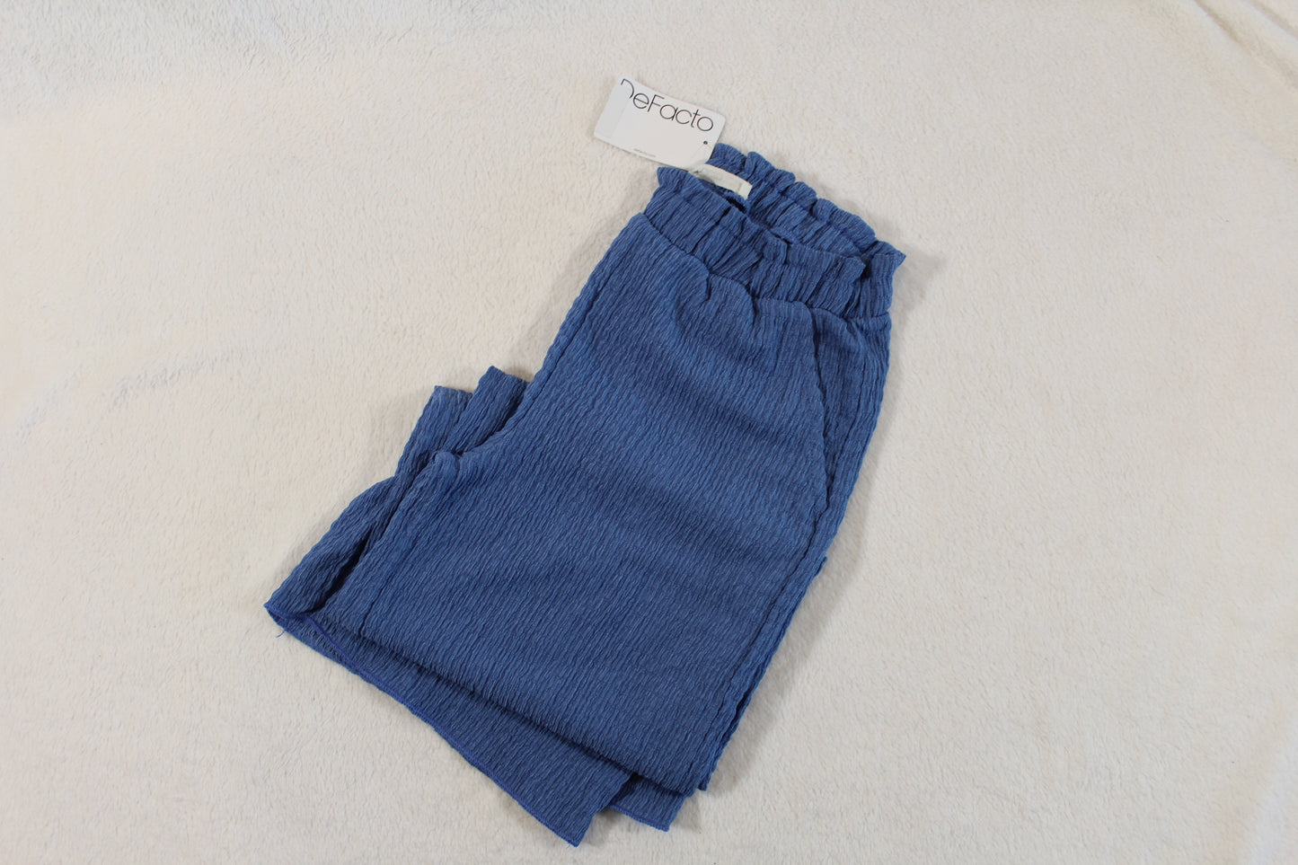 122/128 Stylische Hose in blue with a textured fabric and an elastic waistband, displayed on a light background, suitable for casual wear and secondhand shopping.