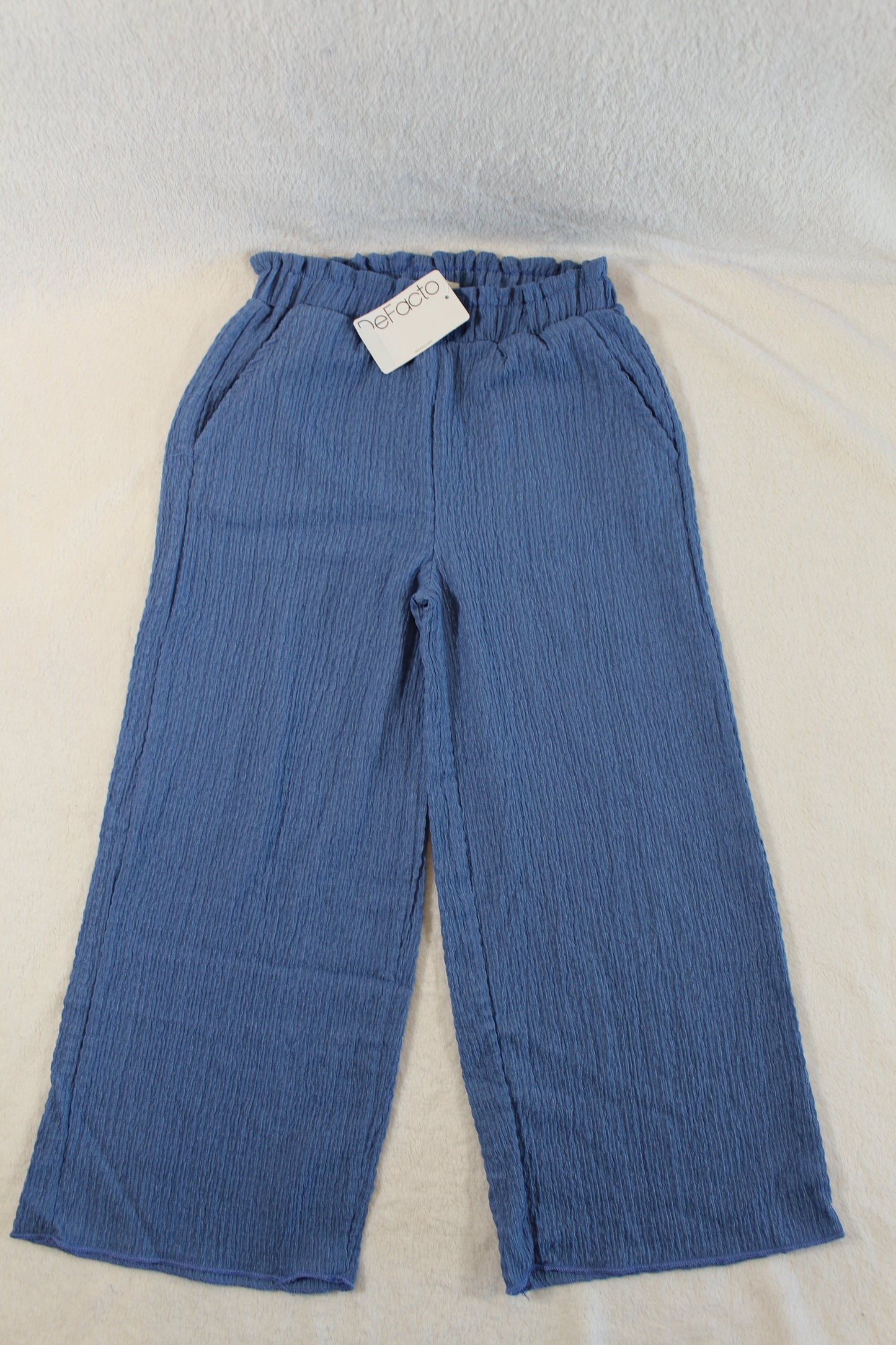 Blue casual wide-leg pants with textured fabric and an elastic waistband, featuring pockets and labeled with 122/128 Stylische Hose for a stylish secondhand option.